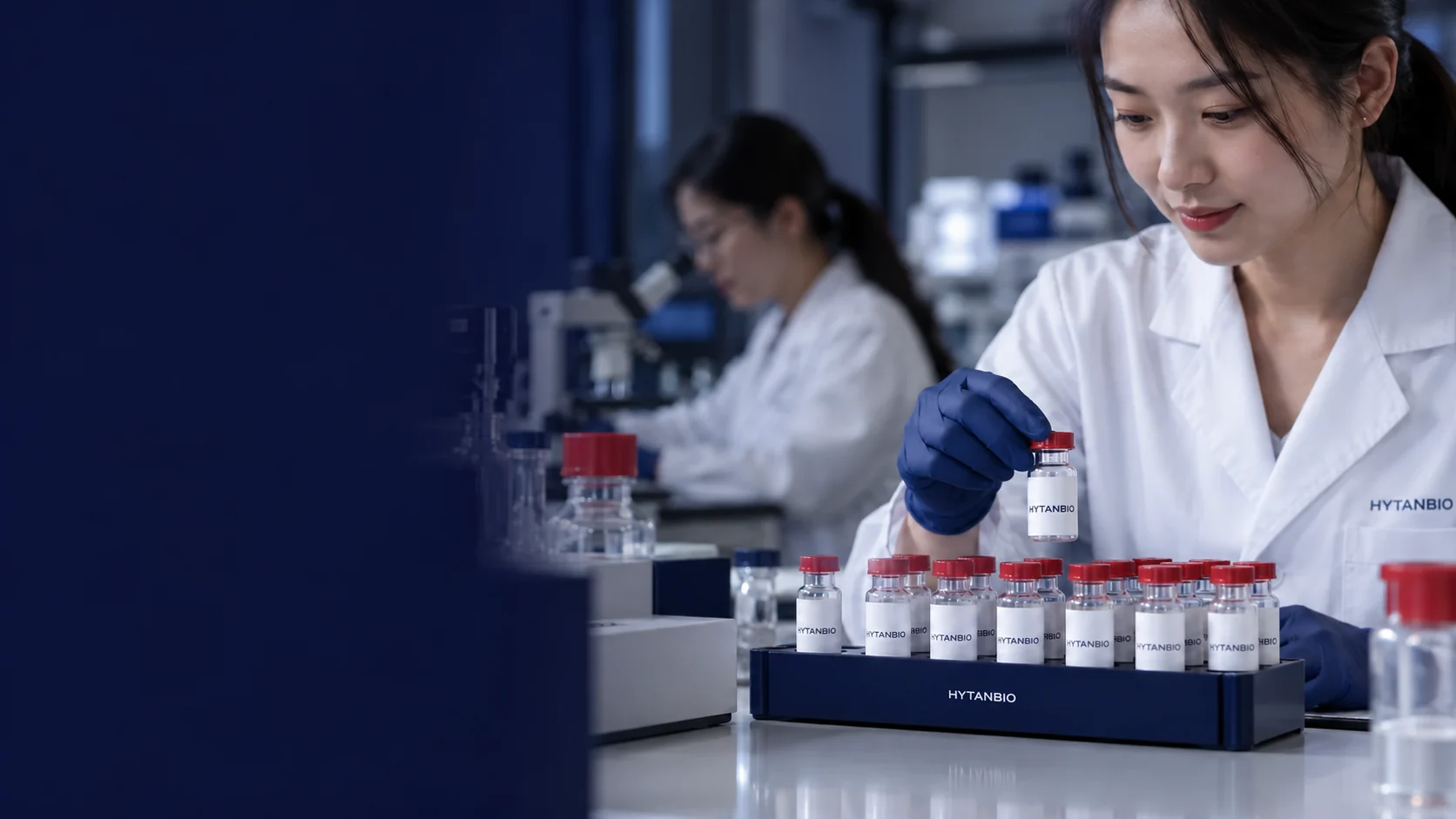 An orderly set of small upright research sample vials in a navy holder on a laboratory bench — illustrative development scene