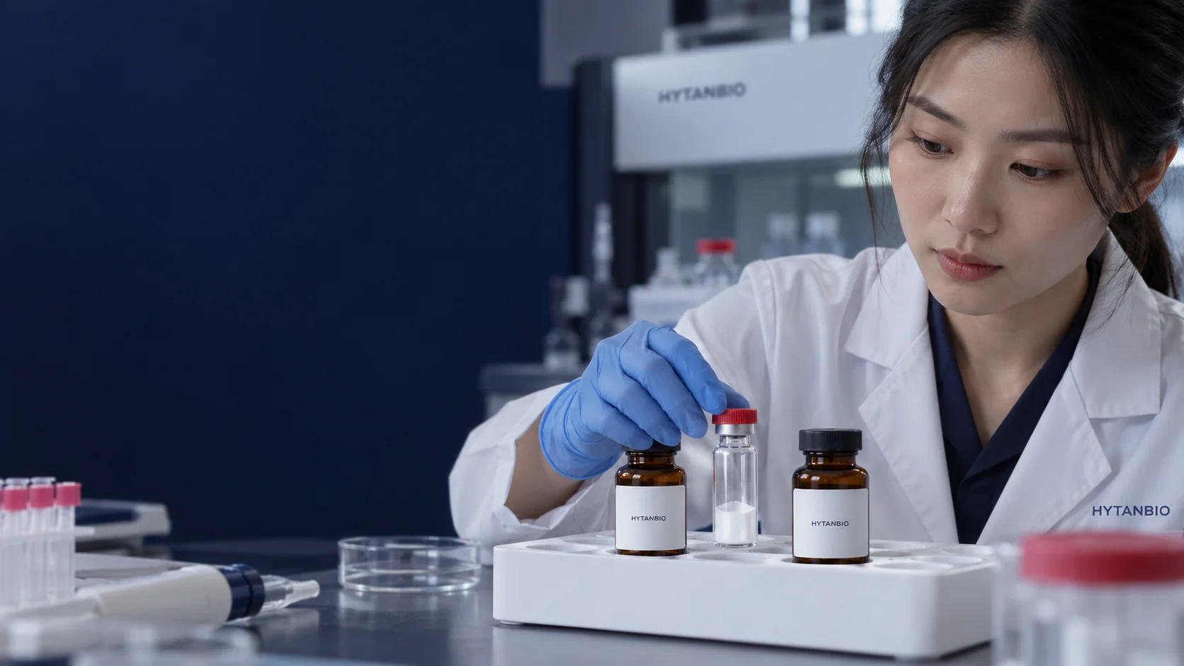 Two closed amber containers and one clear sample vial positioned separately in a white sample tray — illustrative development scene