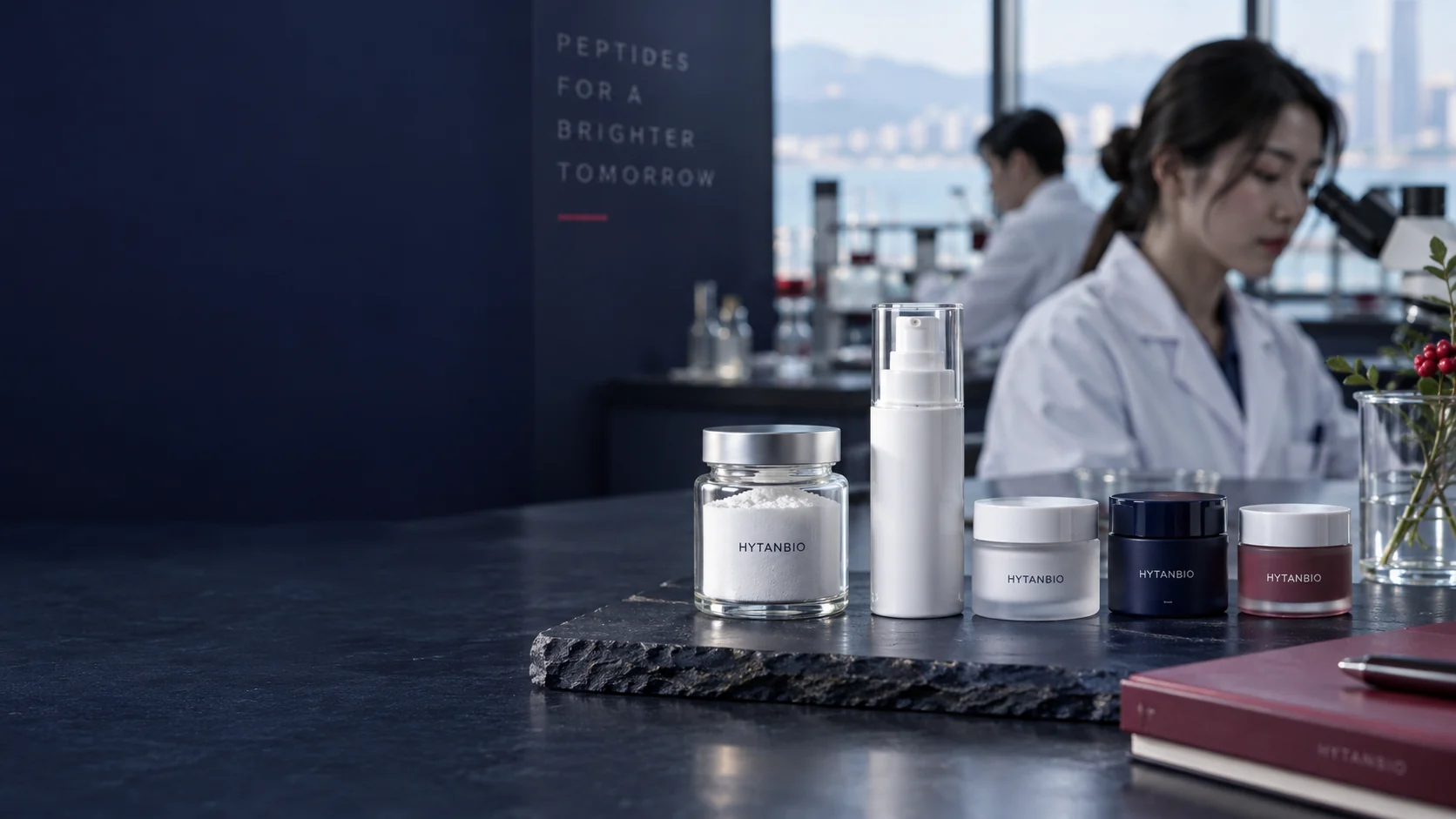 Low eye-level photograph of a single sealed powder jar, an empty white airless pump and three closed cosmetic sample jars on a matte navy stone slab; a distant laboratory window and berry notebook — illustrative development scene