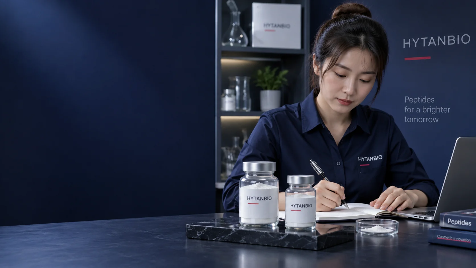 An East Asian woman with a distinct random face and pinned-up hair, in an ordinary navy work shirt, recording a cosmetic raw-material brief; two powder jars stand on a black stone sample stand, her hands hold only a pen — illustrative development scene