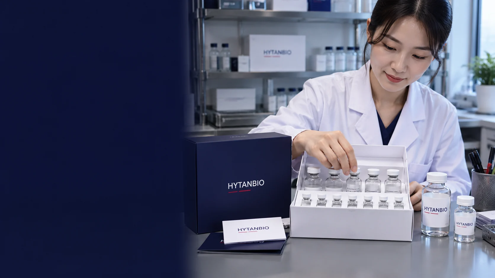 Two sizes of upright clear laboratory solution vials packed in a white carton insert with a neutral navy sample sleeve, packing cards and a gray dispatch bench, no sterile or medical claim — illustrative development scene