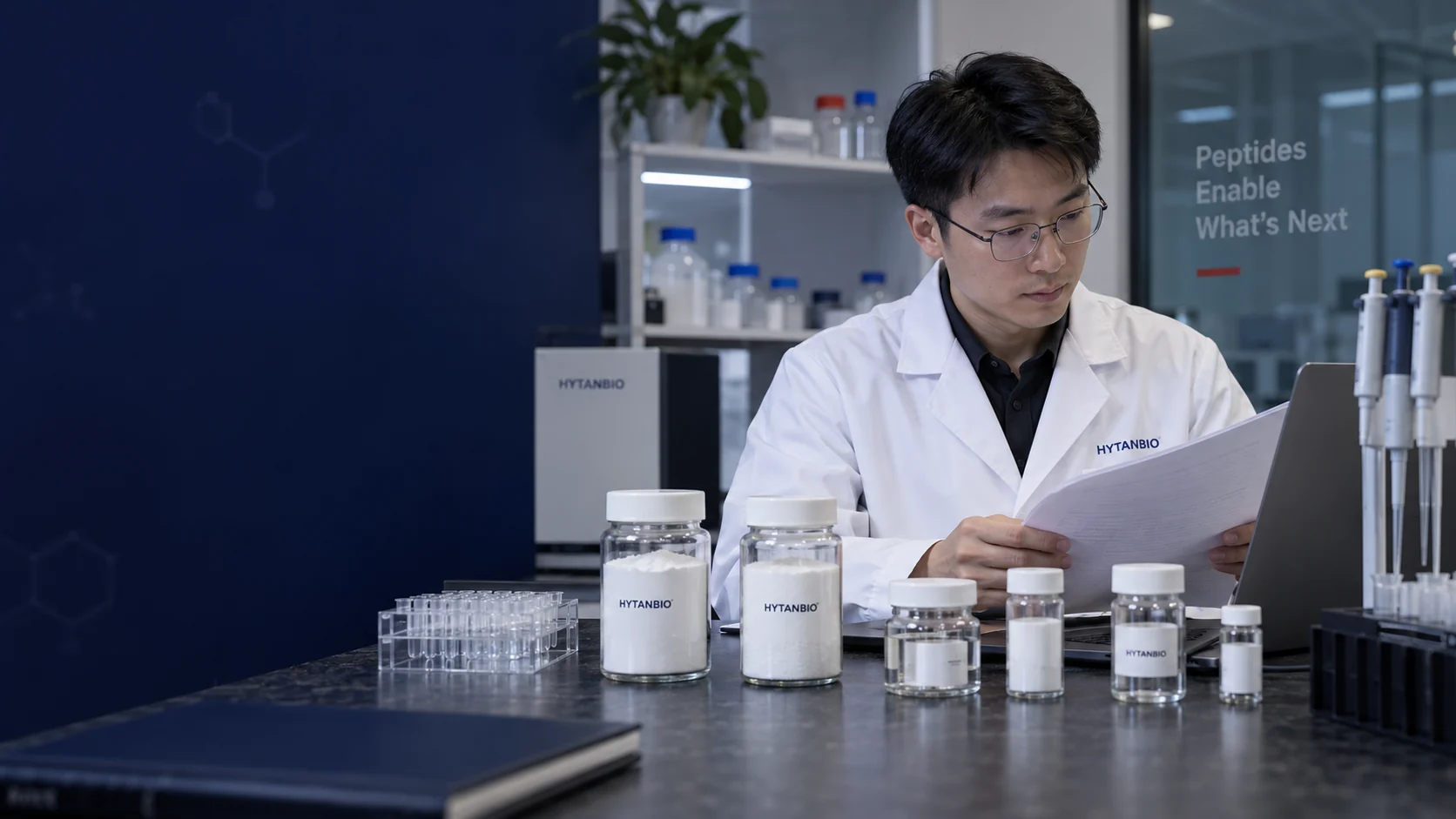 An East Asian male researcher with thin-rimmed glasses looking at a document behind sealed upright research sample jars on a dark stone benchtop; no patient or treatment context — illustrative development scene
