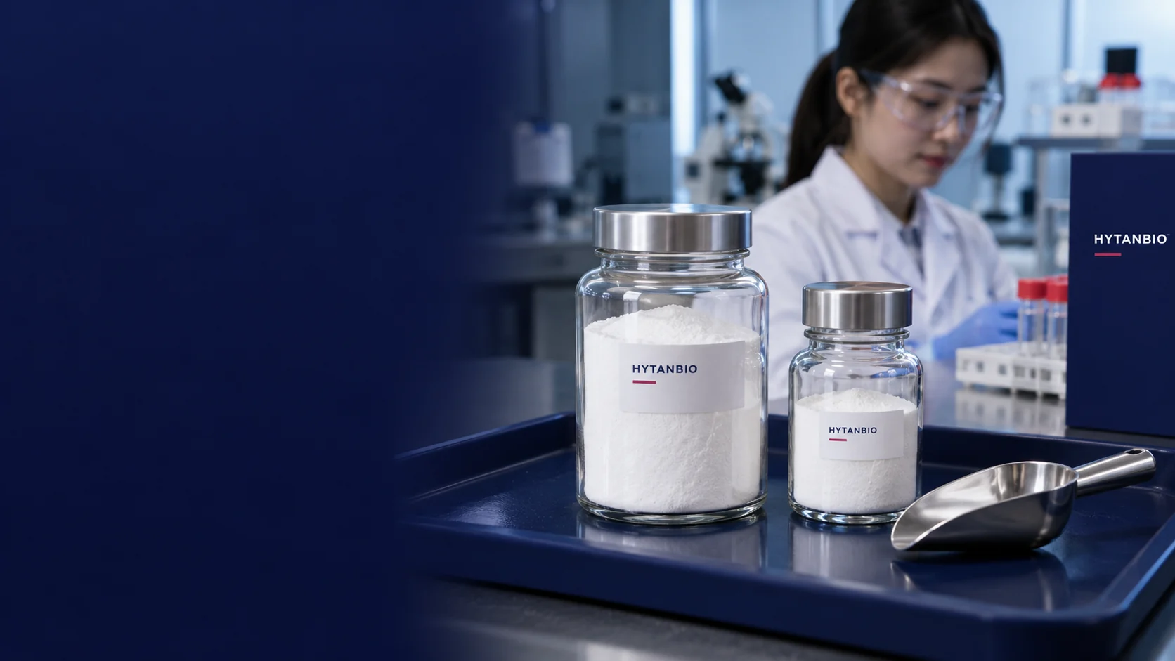 A close photo of two capped glass powder jars of different neck widths and a clean stainless scoop lying on a navy tray, fine white powder visible through glass, believable reflections and ordinary background — illustrative development scene