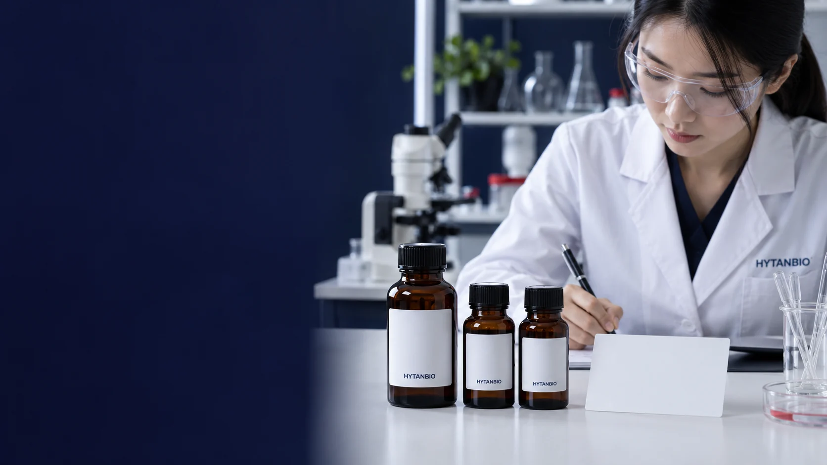 Three upright amber cosmetic ingredient bottles on a white laboratory tabletop beside a blank brief card — illustrative development scene